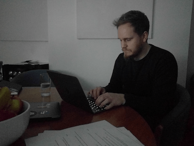 Person using a laptop sitting in a dim room