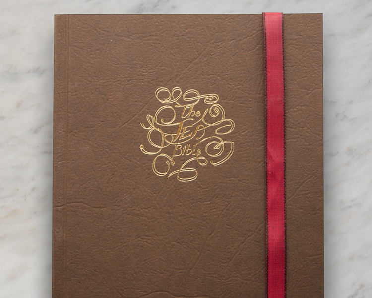 A leather effect book cover with a golden foil debosed script style motif